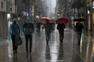 Capitalinos se cubrieron de la lluvia sobre la calle de Madero, en el Centro Histórico