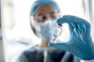 Doctor or laborant holding tube with nCoV Coronavirus vaccine for 2019-nCoV virus